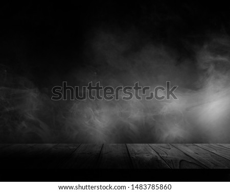 Wooden table with smoke and black backgrounds