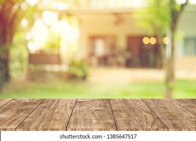 wooden table space with green home backyard view blur background for advertising template