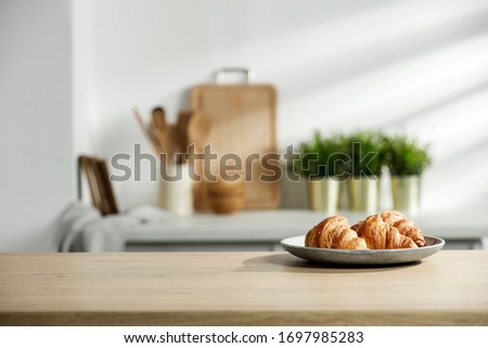 Wooden table in a sunny kitchen in the morning light during breakfast