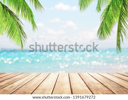 Wooden table top on blue sea and white sand beach background. Coconut palm trees against blue sky and beautiful beach in Punta Cana, Dominican Republic. Vacation holidays background wallpaper. 