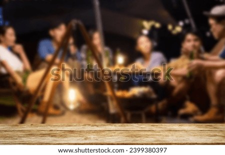 Wooden table top on blur tent camping travel tent at night.Drink and party concept.For montage product display or design key visual layout.View of copy space.