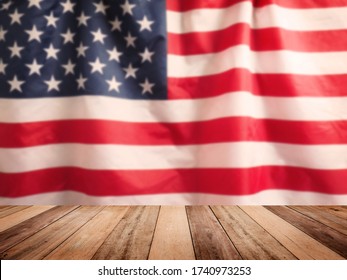 Wooden table top over blurry background of USA flag, vintage filter effect. Montage style to display the product.