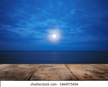 Wooden Table Top Over Summer Beach At Night With Full Moon  Background. Montage Style To Display The Product.