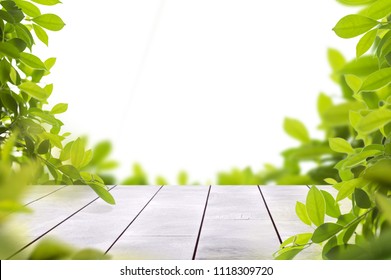 wooden table top with spring green leafs as frame and free space for text - Shutterstock ID 1118309720