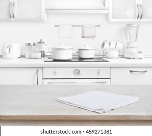 Wooden Table With Towel On Blurred White Modern Kitchen Background