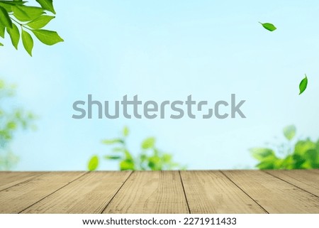 A wooden table with tree leaves swaying in the wind against a blue sky. It evokes the imagery of natural materials and the symbiosis of nature