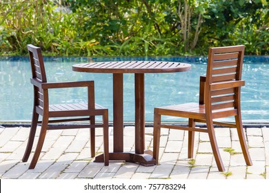 Wooden Table And Two Chairs In Empty Cafe Next To The Swimming Pool, Thailand. Close Up