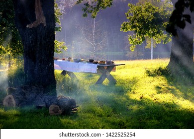 Wooden Table Under Oaks With Traditional Latvian Food. Old Latvian Culture Tradition LIGO. Midsummer Night Celebrating In Latvia. 