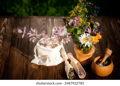 A wooden table with a white cloth sack containing dried herbs, a wooden bowl with a mortar and pestle, and a rustic wooden vase filled with a variety of wildflowers. - Powered by Shutterstock