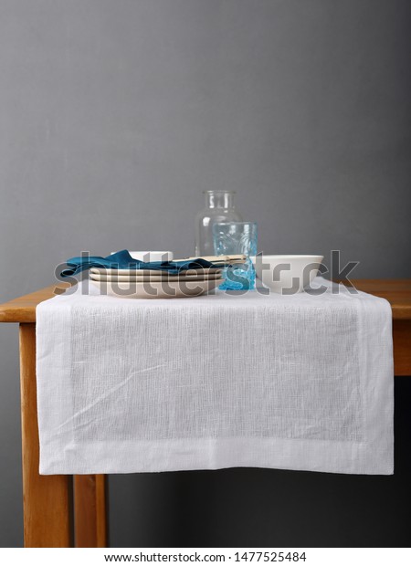 Wooden table and white linen\
runner