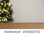 Wooden tabletop with blurred bokeh lights and pine leaves, Christmas holiday, winter concept, product display