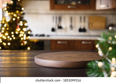 Wooden tabletop with cutting board and blurred kitchen with Christmas tree. Background for display or montage your products. - Powered by Shutterstock