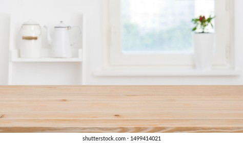 Wooden tabletop in front of blurred kitchen window, shelves background - Shutterstock ID 1499414021