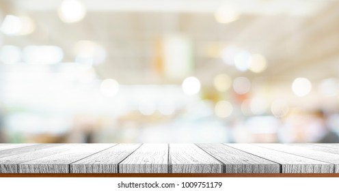 wooden tabletop under image of blurred bokeh light at supermarket