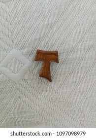 Wooden Tau Cross Pin On White Cloth