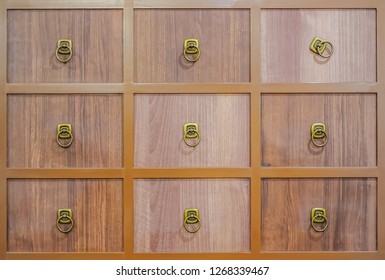 Wooden Textured Drawers Wall Background In Chinese Herbal Medicine Shop In Chinese Drug Store, Crop Of Brown Chinese Lacquered Apothecary Cabinet With Open Drawer.