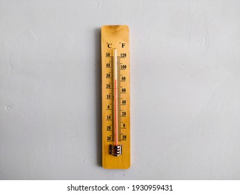 a wooden thermometer with mercury, mounted on the wall to measure room temperature, a temperature thermometer with two readings of Celsius and Farenheit.