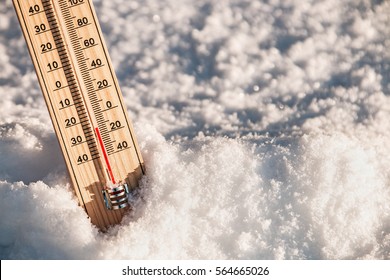 Wooden Thermometer In The Snow With Freezing Temperatures