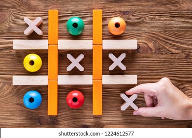 Wooden  tic tac toe (OX) game. The concept of strategy, risk, competition in business.  Woman playing a game of tic tac toe