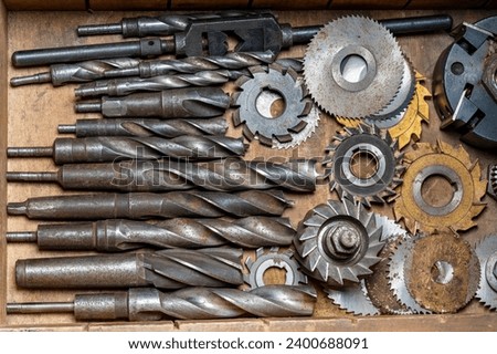 Wooden tool box of tools with old and dirty, rusty drills and saw blades, close up, top view