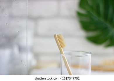 Wooden Toothbrush On A Blurry Bathroom Background. Freshness, Drops Of Water On The Glass.