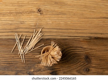 Toothpicks de madera sobre fondo de madera con espacio para copias, escopetas de dientes sin levadura, escopetas de dientes Top View Mockup con espacio para texto, banner de concepto de cuidado dental diario