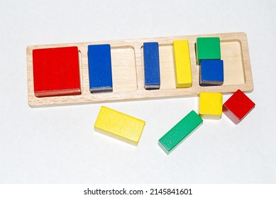 Wooden Toy For Baby, Children Isolated On White Background. Quads Of Different Colors Are Divided Into Pieces Of Different Sizes.