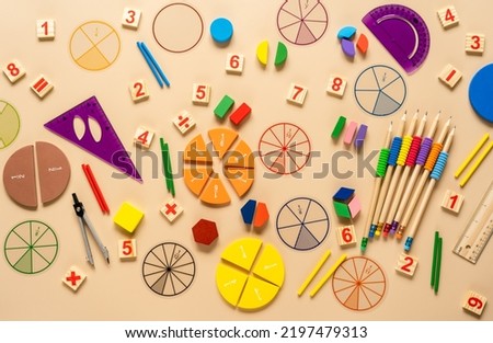 Wooden toy blocks. School supplies, math fractions, pencils, numbers, on beige background. Back to school, education concept background