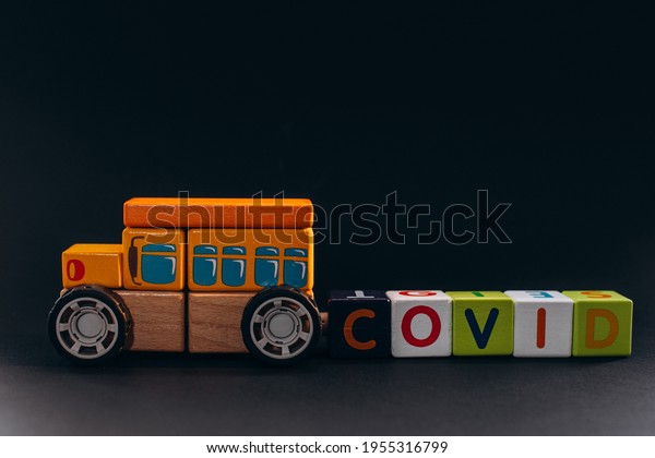 Wooden toy\
bus with cubes letters showing covis\
sign