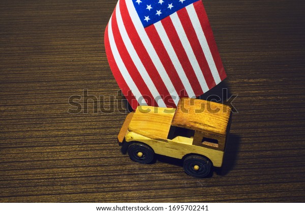 wooden toy\
car and american flag on wooden\
background
