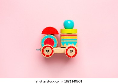 Wooden Toy Car With Colorful Blocks On Pink Background Top View