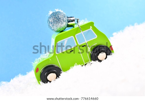 Wooden Toy Car Delivering a Christmas Decoration in\
the Snow