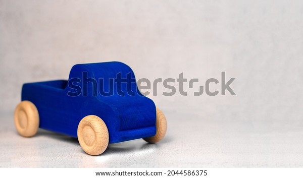A wooden toy car on\
a light background.