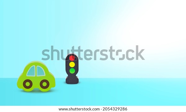 Wooden toy car and traffic lights on blue\
background. Road safety\
concept
