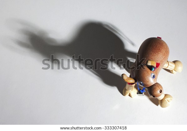 Wooden toy cow with articulated. Dramatic\
lighting and shadows.