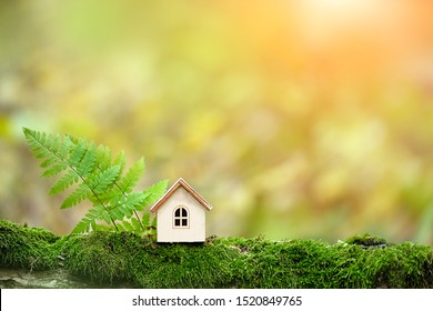 Wooden Toy House In Forest. Symbol Of Happiness, Family, Mortgage, Real Estate Concept. Eco Friendly House. Creative Minimal Design. Copy Space