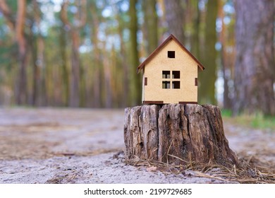 Wooden Toy House Model Placed On An Old Tree Stump In The Forest