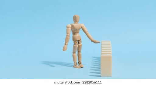 Wooden toy mannequin keeps dominoes from falling, risk prevention concept - Shutterstock ID 2282056111