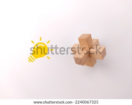 A wooden toy puzzle with an idea icon on a white background- solution concept