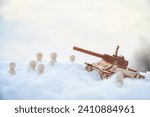 Wooden toy Russian tank T-34 and little men in the snow. Russia and Ukraine are at war in winter. Encirclement, retreat, attack, victory