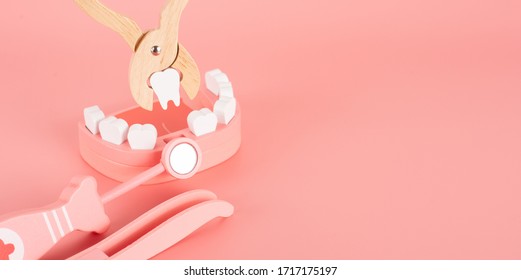 Wooden Toy Set Flat Laying On The Pink Background In The Concept Of Dental Caries, Remove Tooth, Gum Disease, Toothache  And Having Good Health.