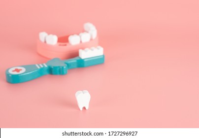 Wooden Toy Set Flat Laying On The Pink Background In The Concept Of Dental Caries For The Elderly, Heart Disease, Gum Diseases, Dental Implant, Missing Tooth And Having Good Dental Health.