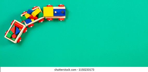 Wooden toy train with colorful blocks on green background