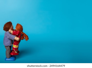 Wooden toys of a father and daughter hugging, set against a blue background. A heartwarming representation of family love and affection - Powered by Shutterstock