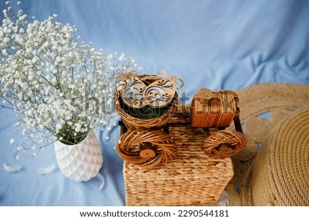 A wooden tractor. Blue background. White flowers in a white vase