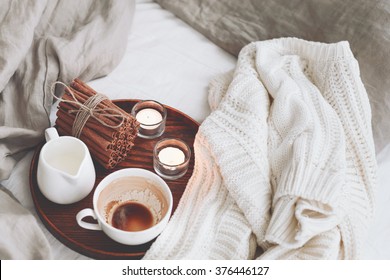 Wooden Tray With Coffee, Milk, Cinnamon Sticks And Tea Candles In The Bed, Lazy Morning, Warm Winter Mood