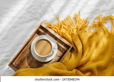 Wooden Tray With Coffee And Warm Plaid On White Bedding . Breakfast In Bed. Hygge Concept.