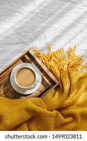 Wooden Tray With Coffee And Warm Plaid On White Bedding . Breakfast In Bed. Hygge Concept.