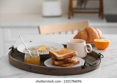 Wooden tray with delicious breakfast on white marble table in kitchen, space for text - Powered by Shutterstock