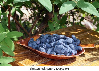 A Wooden Tray Filled With Freshly Harvested Fruits. Kamchatka Berries. 